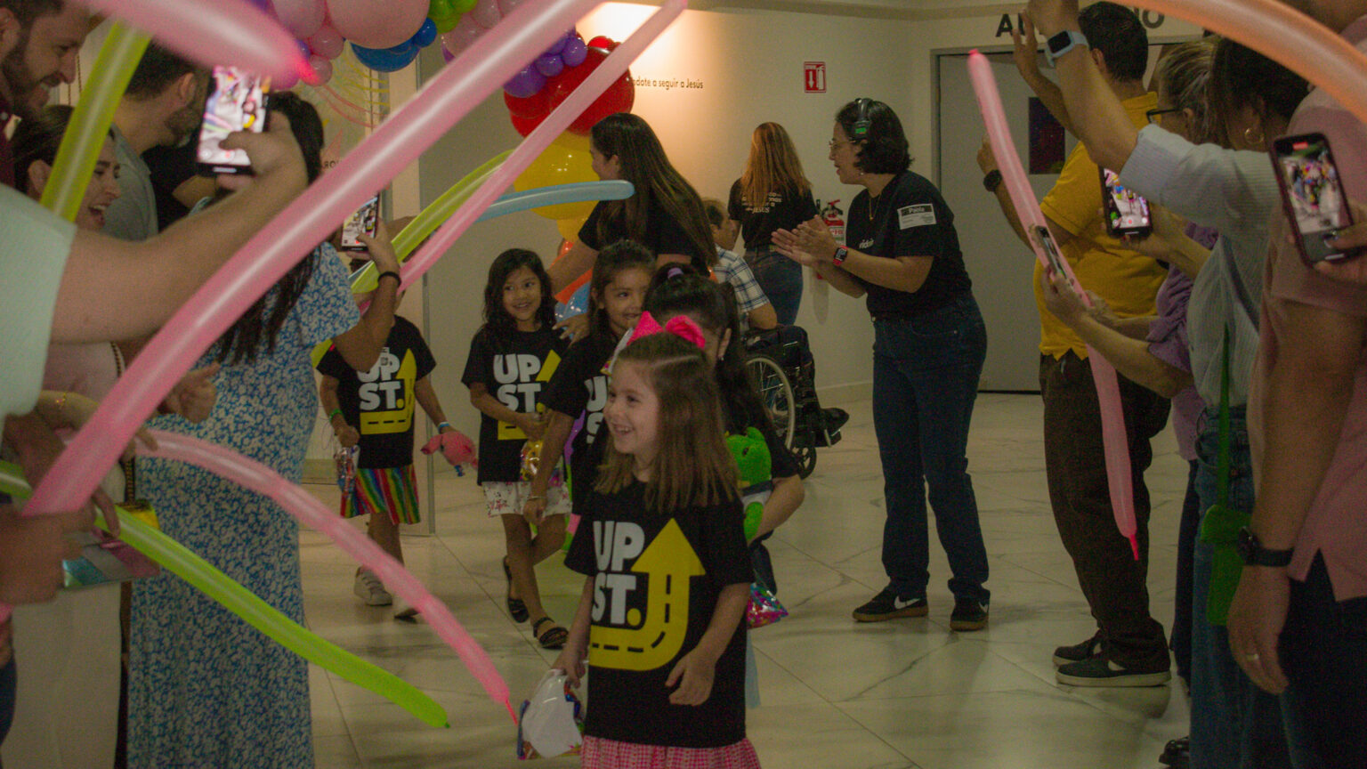 Kids and volunteers celebrating with colorful balloons