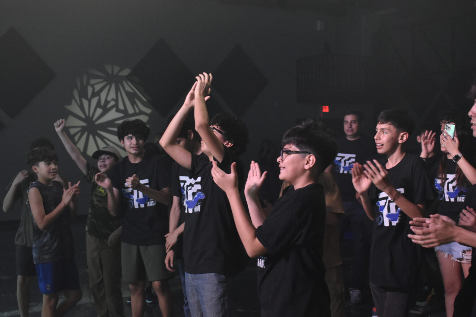Students with their hands raised at a worship night