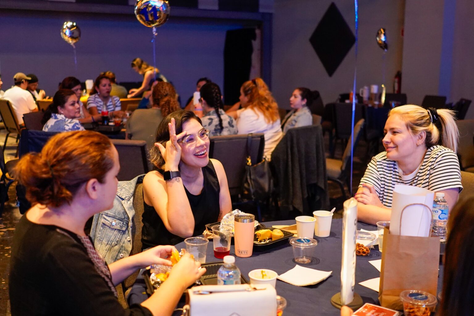 Women talking and laughing around a table
