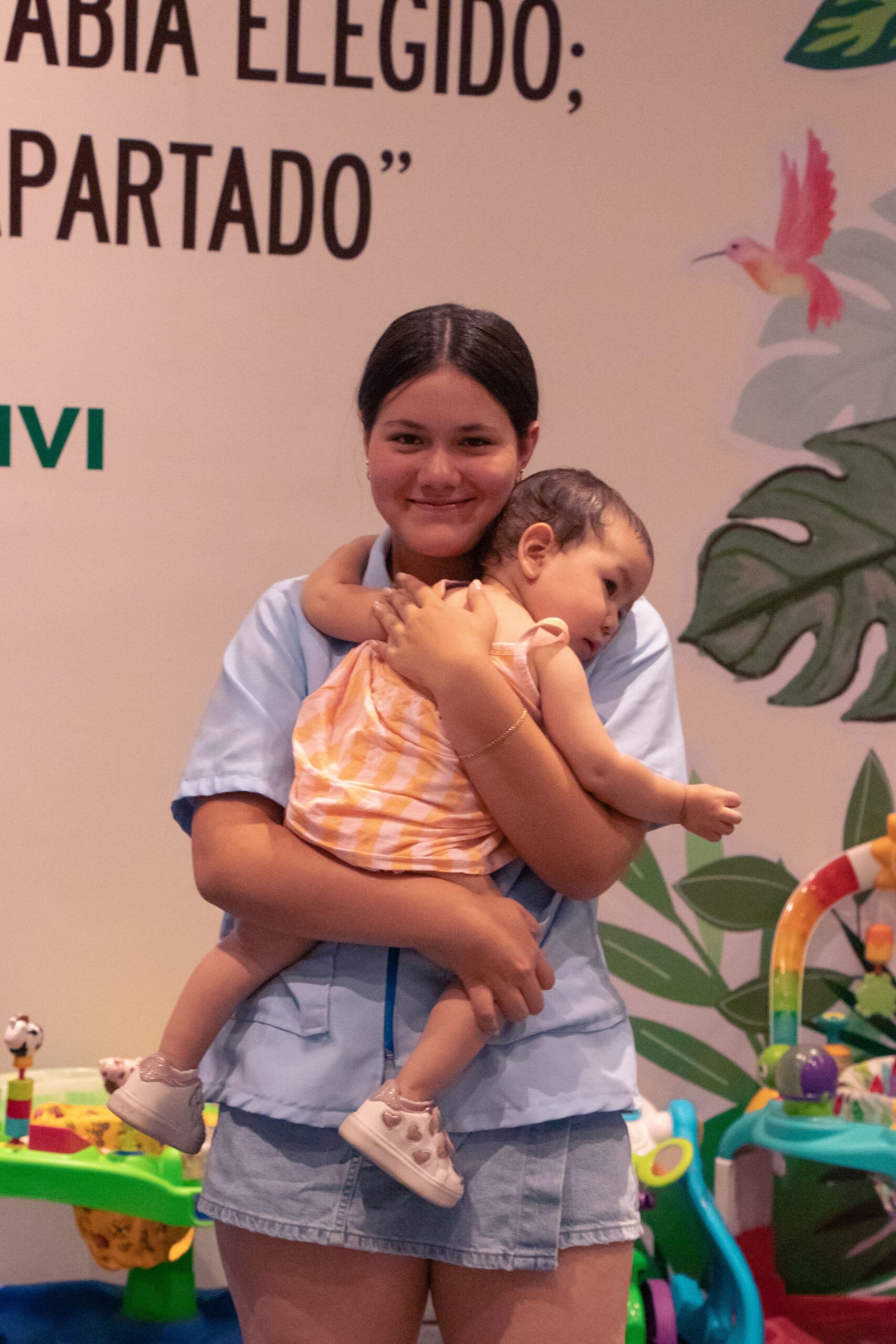 A young woman holding a baby girl in the families space