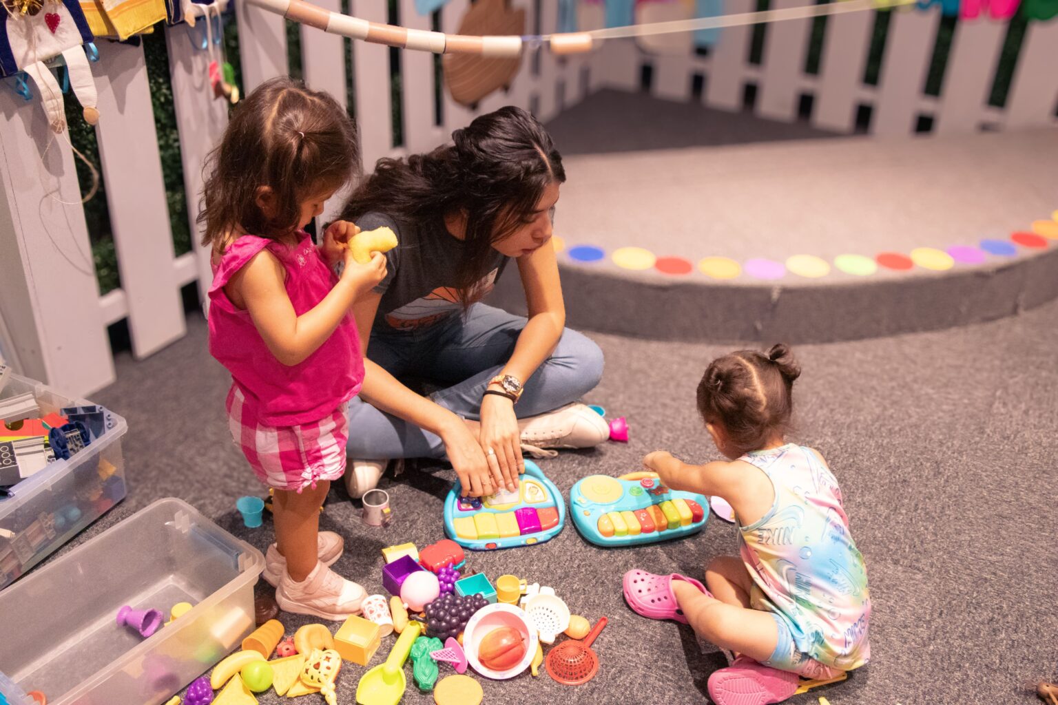 Girls playing on the floor of the kids space