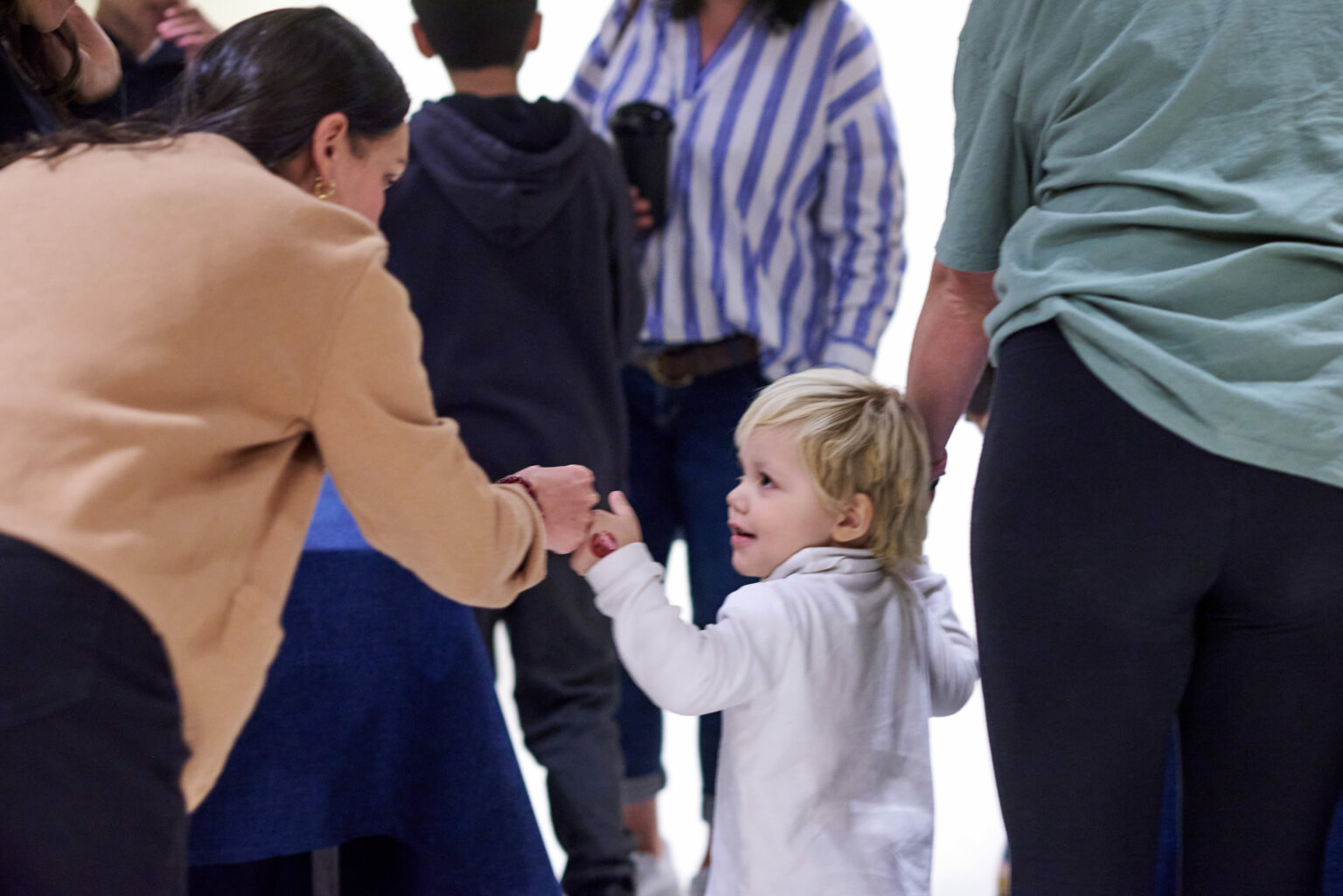A child holding hands with two adults