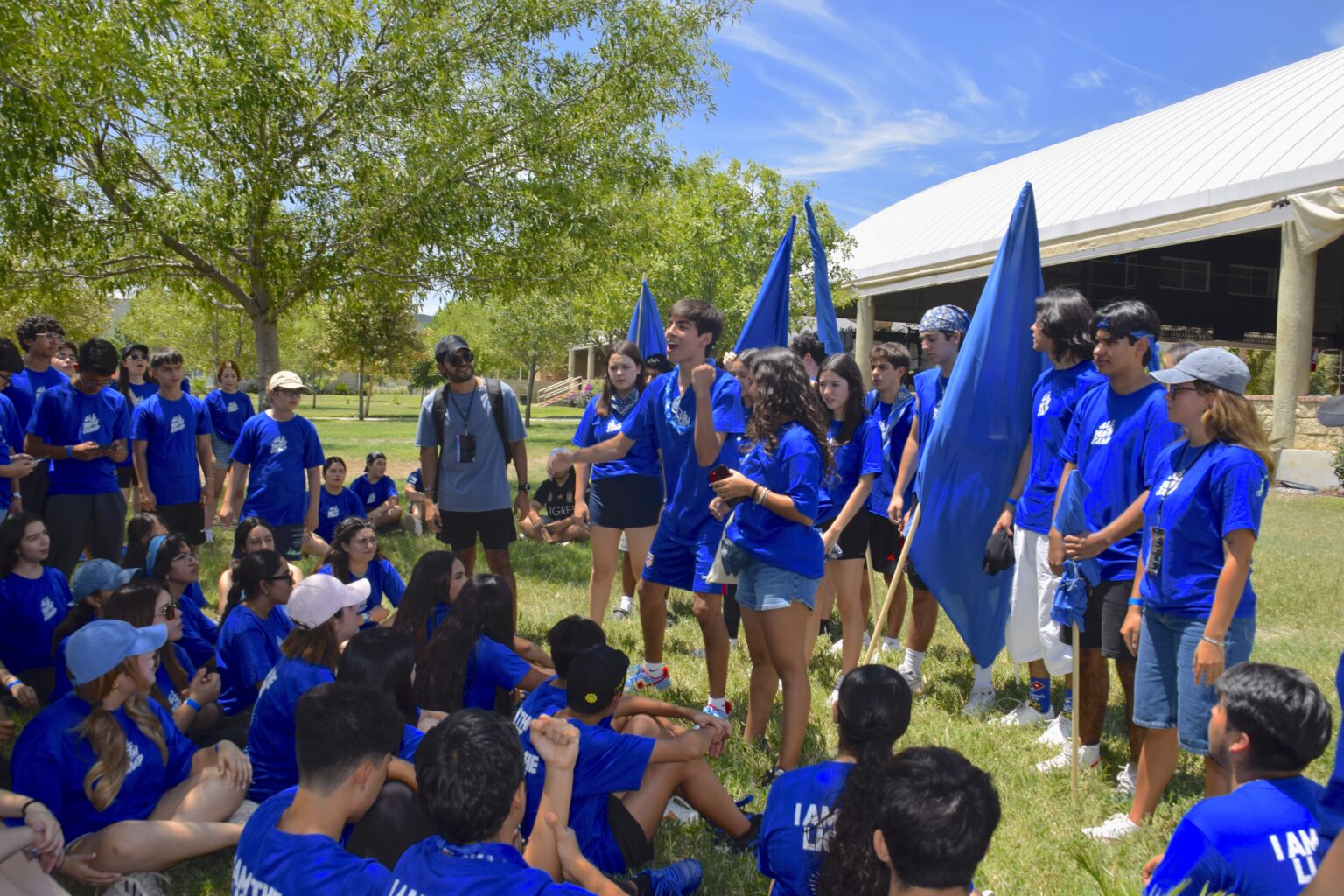 Students gathered with blue flags at camp