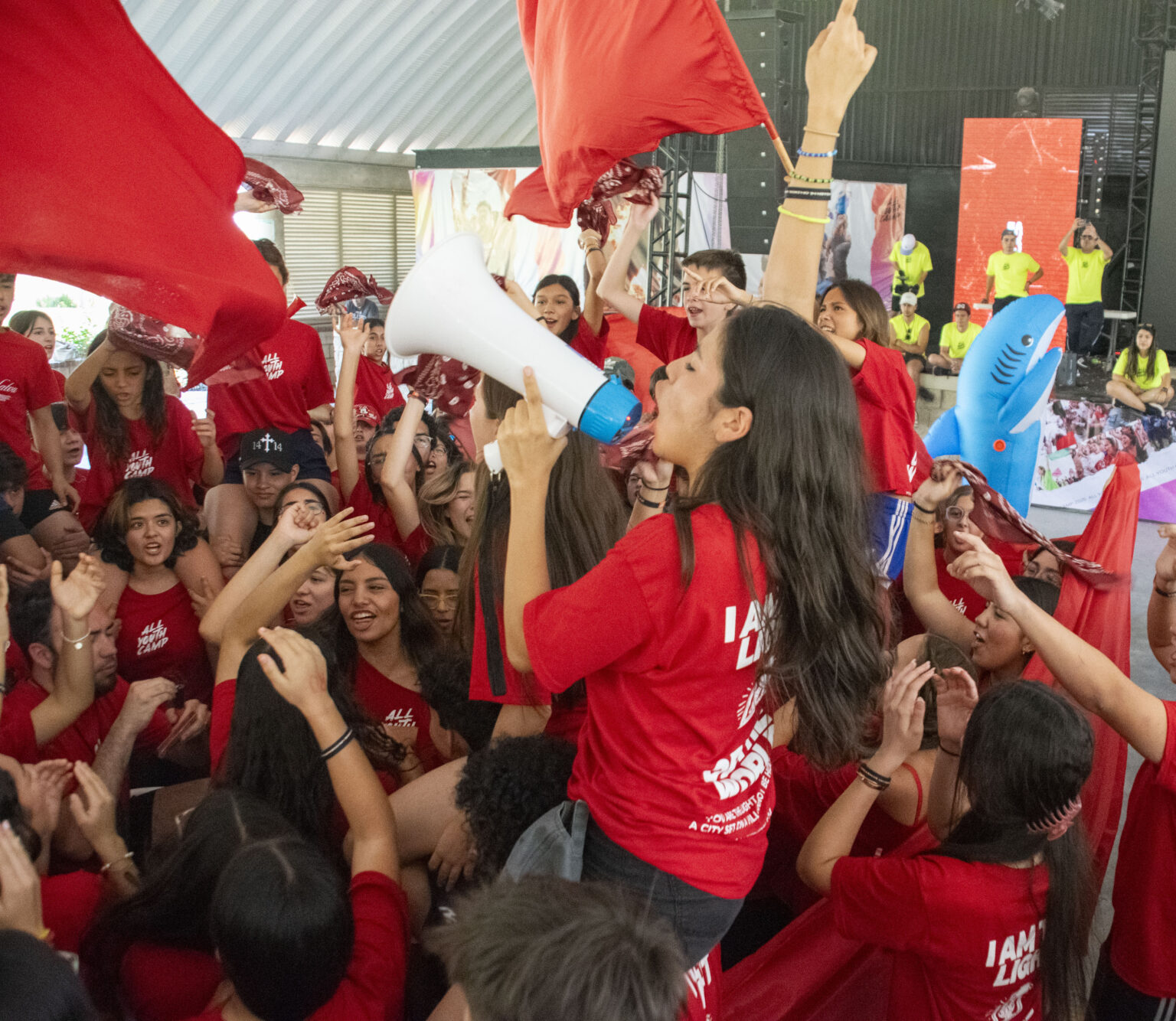 A student cheering with a megaphone and a flag