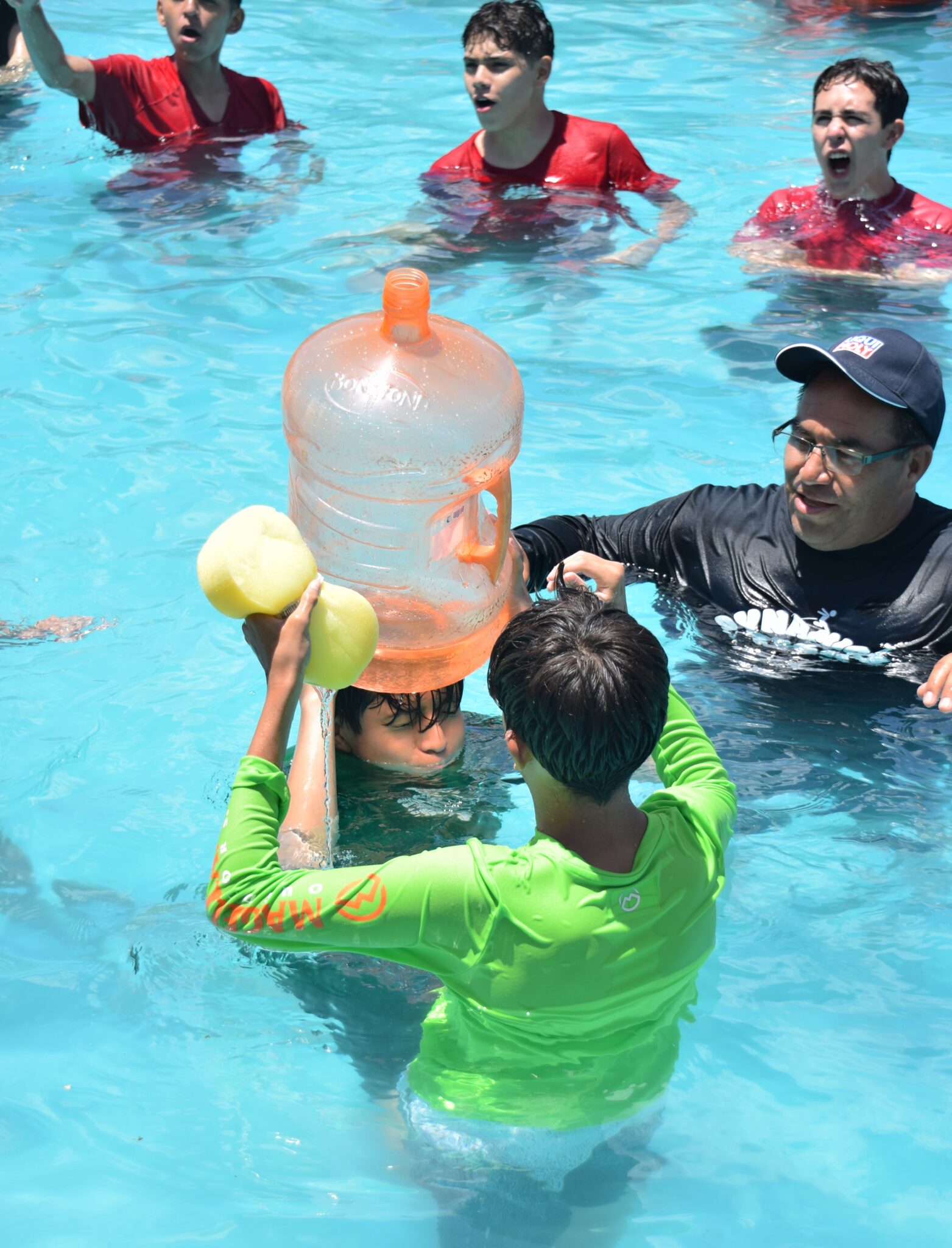 An adult playing with kids in the pool