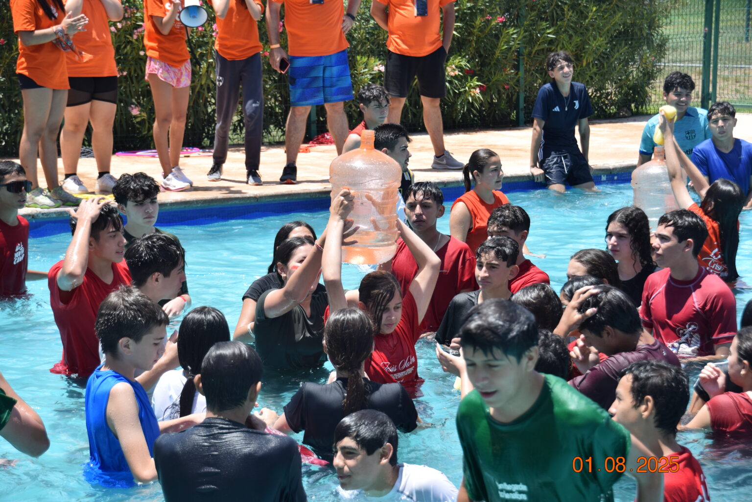 Young people hanging out in the pool during camp